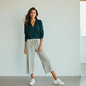 Confident Woman in Green Wrap Top and Gray Pants