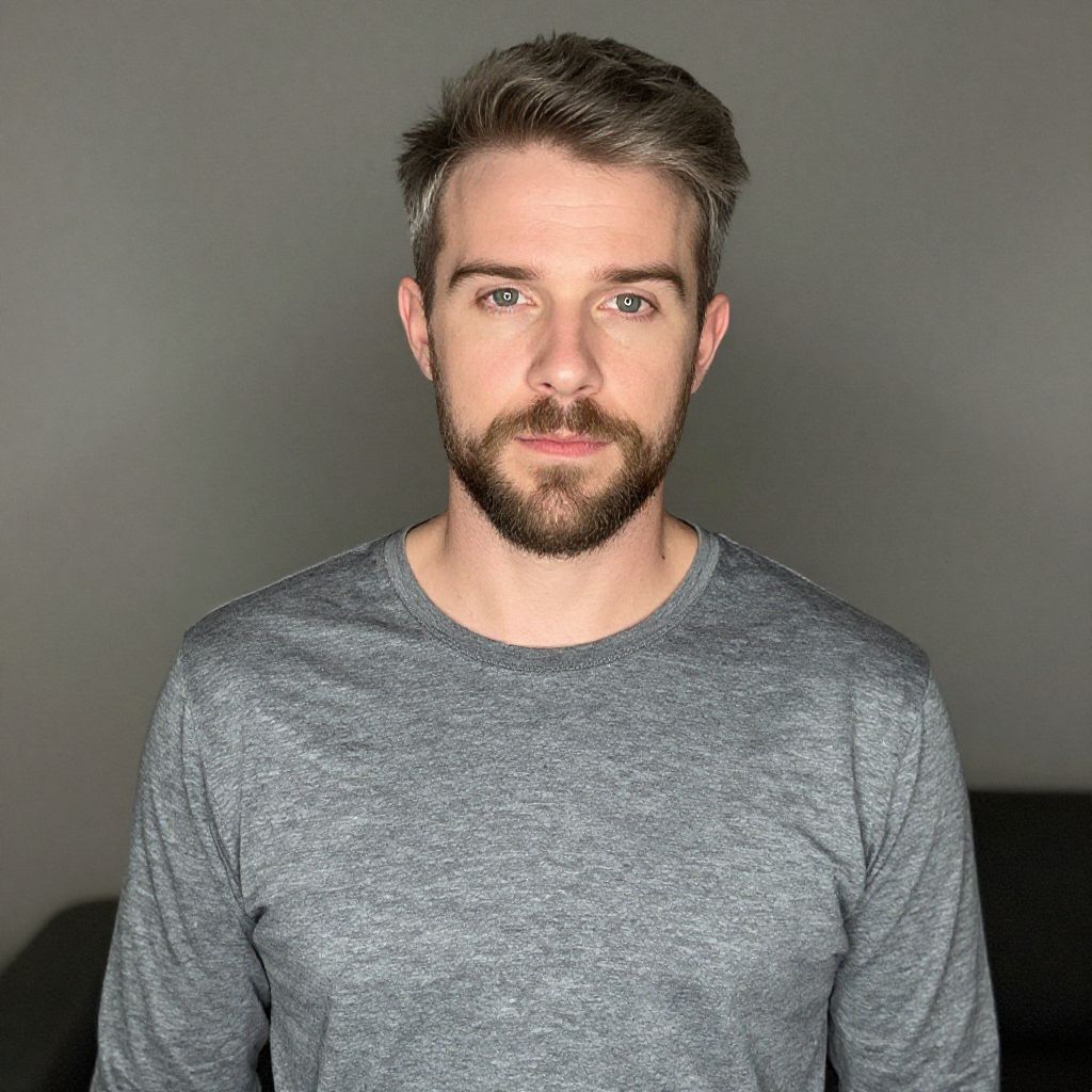 Portrait of Young Man in Gray Long-Sleeve Shirt Against Neutral Background