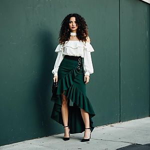 Fashionable Woman in Elegant Off-Shoulder Blouse and Ruffled Skirt on City Street
