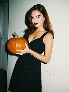 Woman Holding Pumpkin at Halloween Party in Black Dress