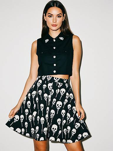 Modern Edgy Woman Wearing Cropped Black Sleeveless Shirt and High Waist Skull Print Skirt
