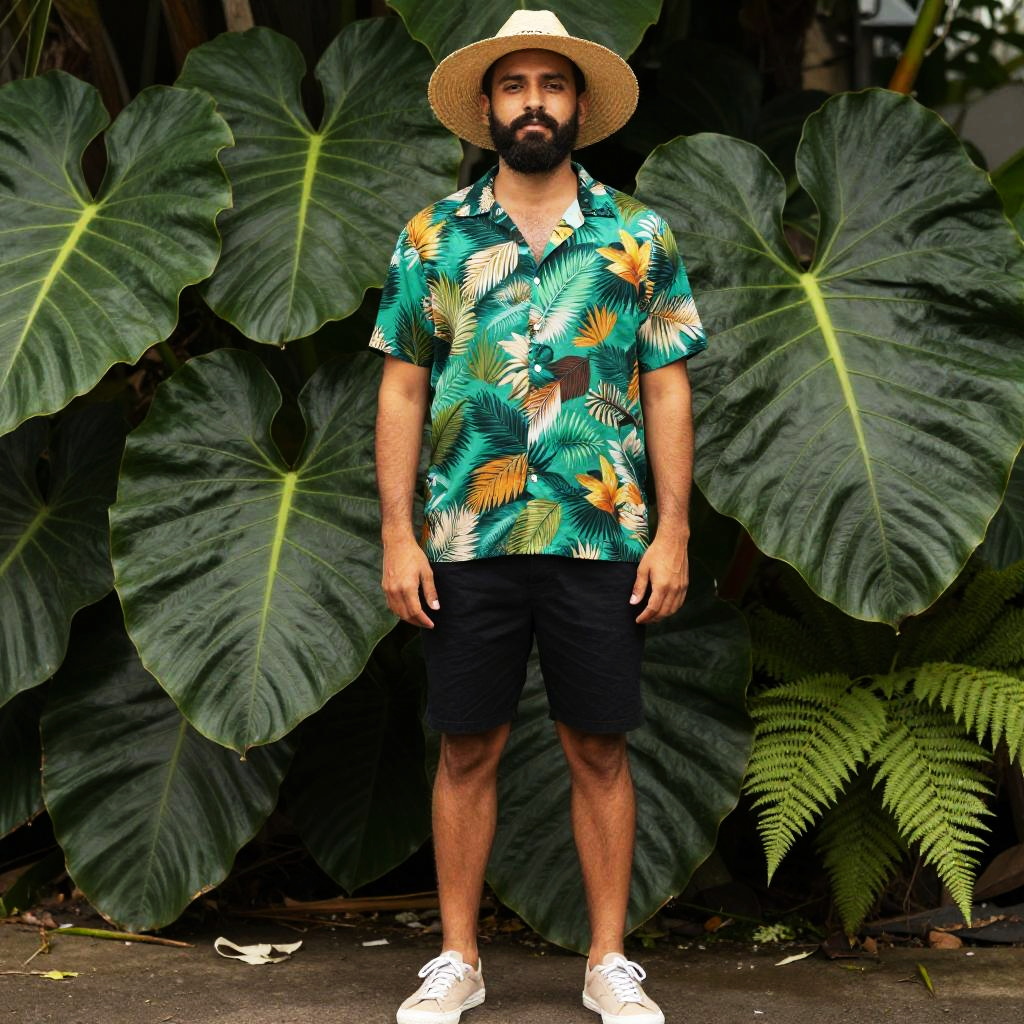 Man in Tropical Hawaiian Shirt and Straw Hat Standing by Giant Leaves