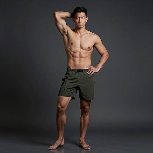 Fit Young Man Posing in Olive Green Shorts in Fitness Studio