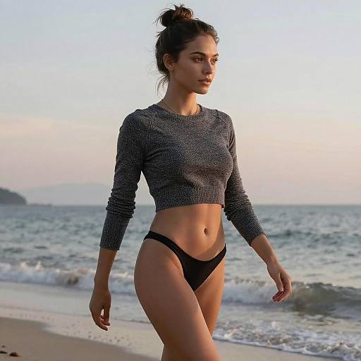 Woman in Cropped Sweater and Bikini Bottoms Walking on Beach at Sunset