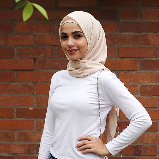 Young Woman Wearing Hijab Posing Against Red Brick Wall