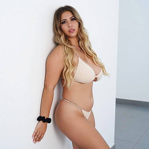 Confident Woman Posing in Nude Bikini Against White Wall