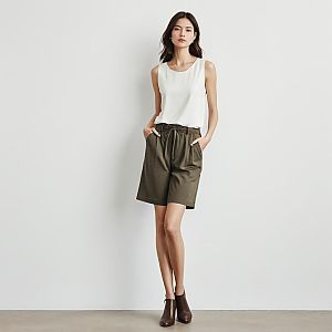 Confident Woman in White Top and Olive Shorts