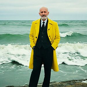 Mature Man in Yellow Coat on Shore