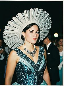 Elegant Woman in Sparkling Turquoise Gown with Silver Fan Headpiece at Gala