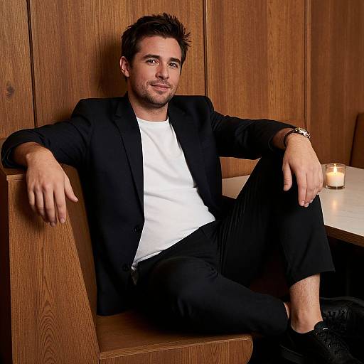 Relaxed Man in Casual Suit Sitting in Wooden Booth with Candlelight