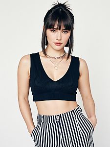 Woman in Contemporary Casual Black Ribbed Crop Top with Deep V Neckline and Striped Pants