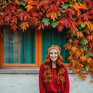 Smiling Woman with Red Hair in Autumn Leaves