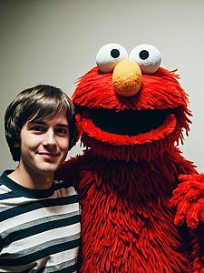 Young Man Posing with Classic Red Elmo Costume Character