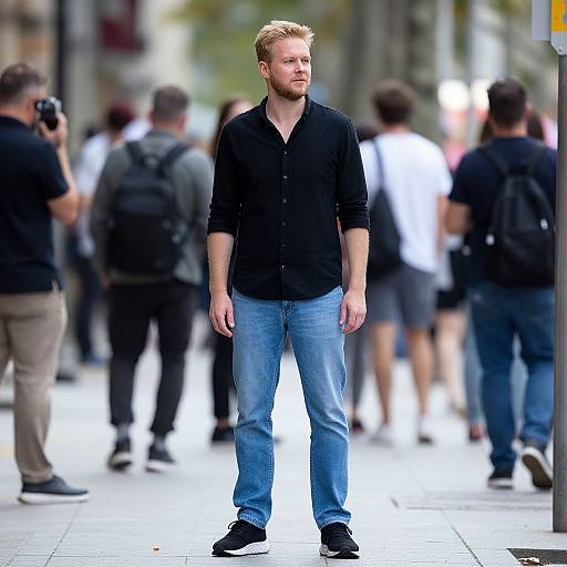 Man Standing on City Sidewalk in Casual Black Shirt and Jeans