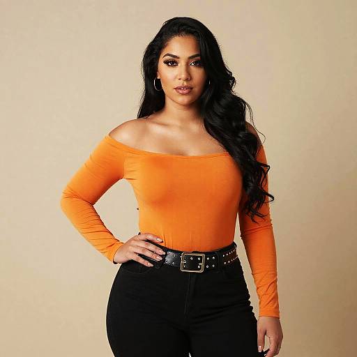 Confident Woman in Orange Off-Shoulder Top and Black Jeans