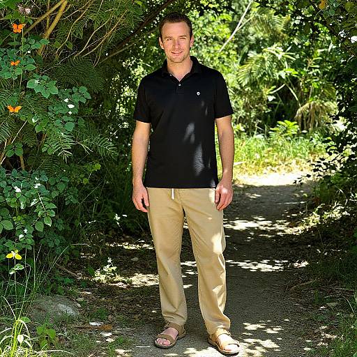Man Standing on a Forest Trail in Casual Attire with Butterflies