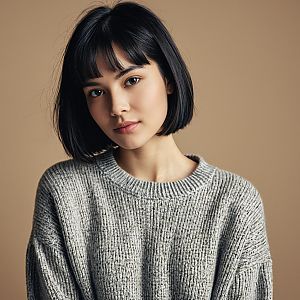 Young Woman with Black Bob Haircut in Grey Sweater