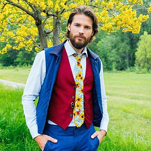 Confident Man in Stylish Outfit Near Yellow Blossoms