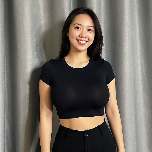 Young Woman in Black Crop Top and Pants Smiling Indoors