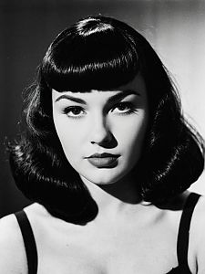 Vintage Glamour Woman with Bettie Page Bangs Hairstyle Black and White Portrait
