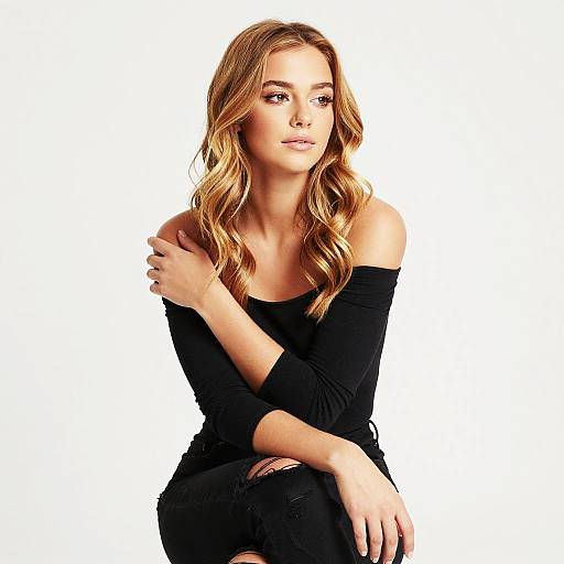 Young Woman in Black Off-Shoulder Top with Wavy Blonde Hair