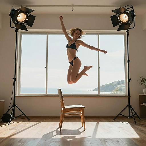Young Woman Jumping in Bikini on Chair Wide Angle Studio Shot