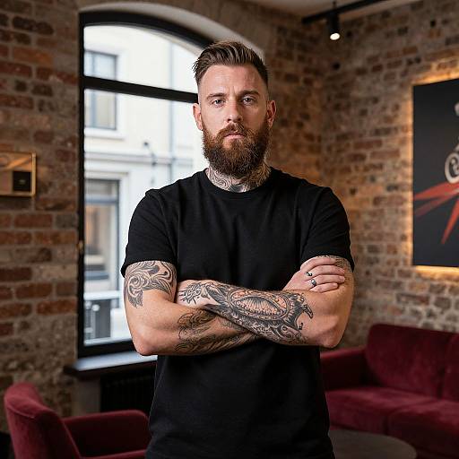 Confident Bearded Tattooed Man in Modern Industrial Room