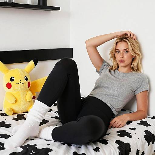 Relaxed Young Woman in Casual Wear with Pikachu Plush on Cow-Print Bed