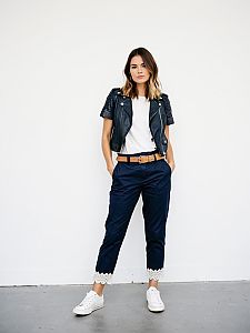 Young Woman in Short Leather Jacket and Navy Pants with Lace Trim