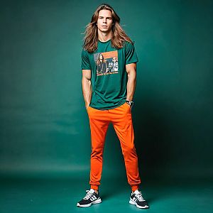 Confident man in green t-shirt and orange joggers