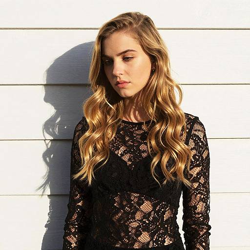 Young Woman in Black Lace Top Against White Wall