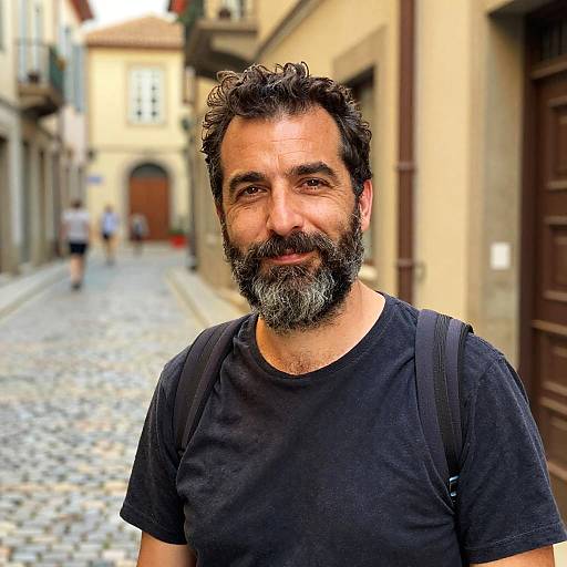 Bearded Man with Backpack on Cobblestone Street in European Town