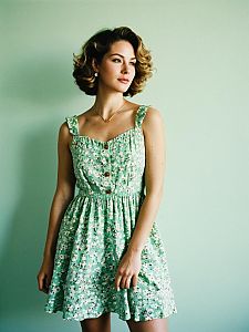 Woman in Vintage Green Floral Dress with Soft Lighting