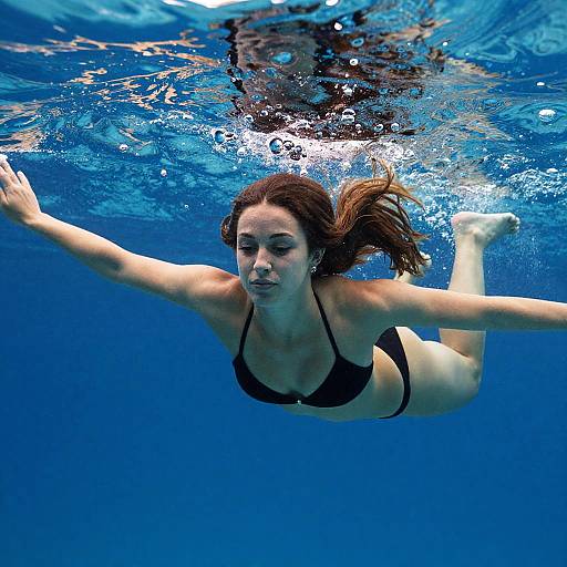Underwater Woman Swimming in Black Bikini in Clear Blue Pool