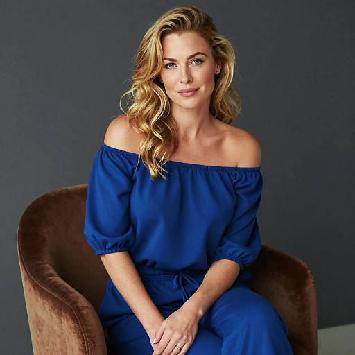 Blonde Woman in Elegant Blue Off-Shoulder Dress Sitting on Brown Chair