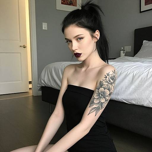 Portrait of Woman with Floral Tattoo and Dark Lipstick in Minimalist Bedroom vllm2604030503c03g