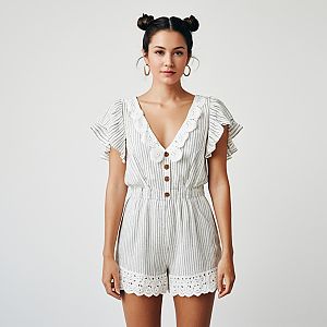 Confident Woman in Striped White Romper with Lace Details