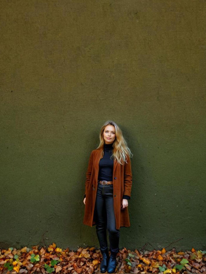 Stylish Woman in Brown Coat Against Green Wall