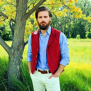 Bearded man outdoors by yellow blossom tree