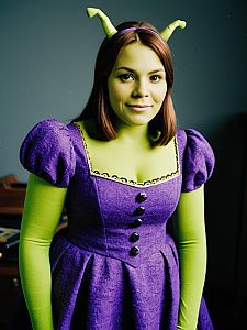 Woman in Purple Dress Shrek Costume with Green Face Paint and Antennae