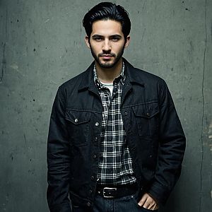 Confident Young Man in Grunge Outfit Against Concrete Wall