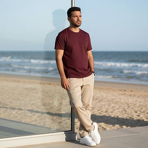 Man in Casual Outfit Leaning on Glass Wall by Beach