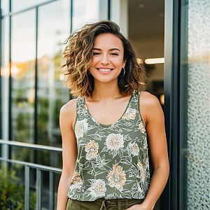 Young woman smiling outdoors in a floral top