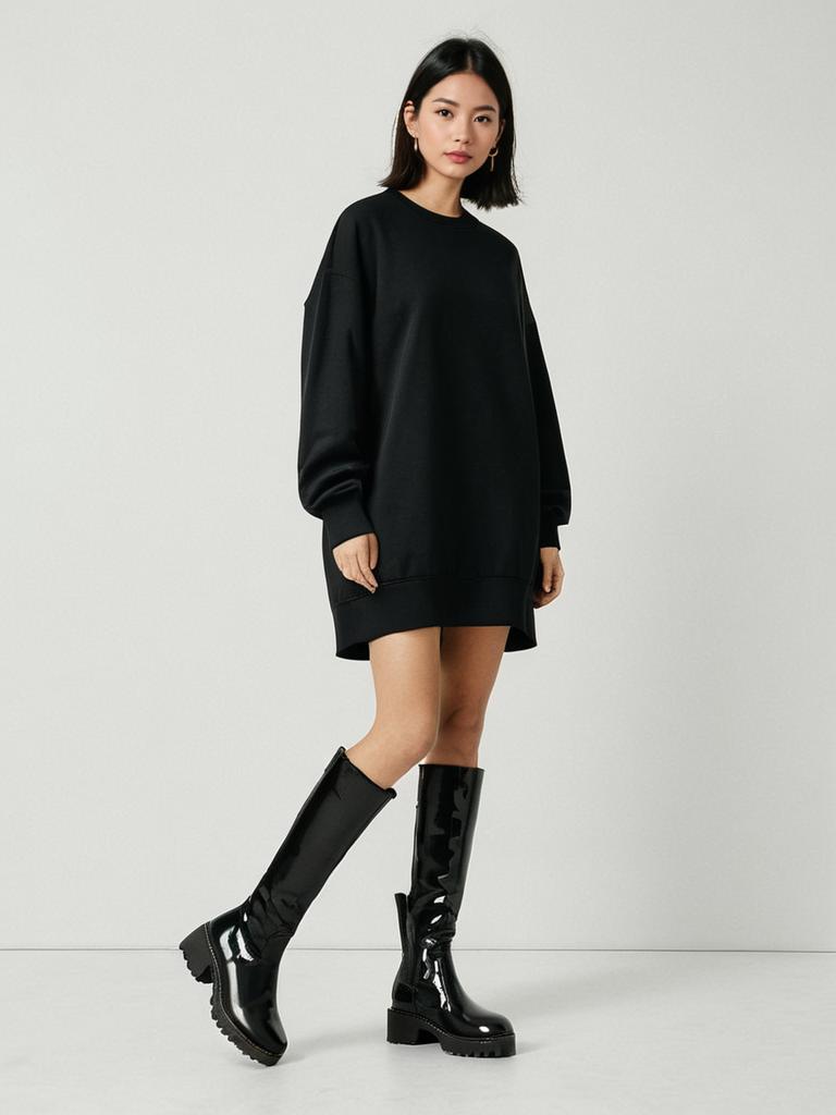 Woman Wearing Minimalist Oversized Black Sweatshirt Dress with Knee-High Boots