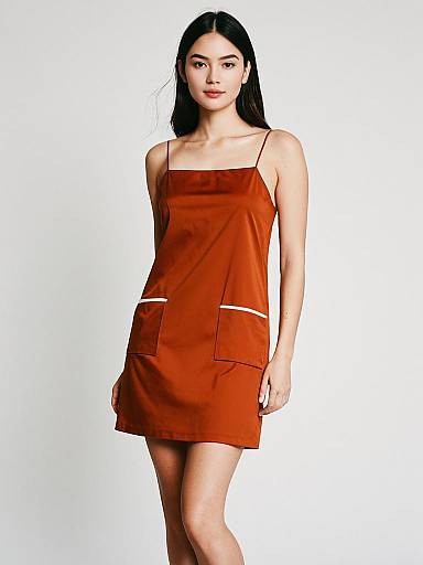 Woman Wearing Minimalist Burnt Orange Spaghetti Strap Slip Dress with Pockets