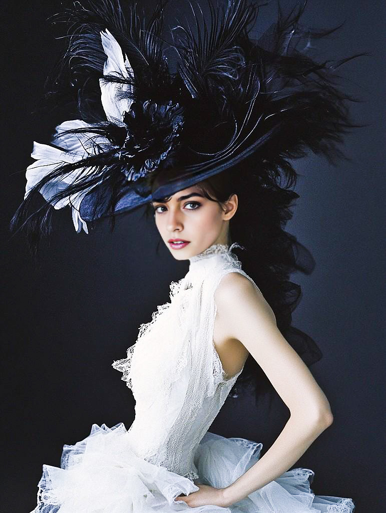 Elegant Woman in Black Feathered Hat and White Dress