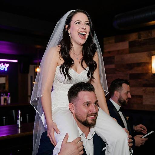Happy Bride Sitting on Shoulders of Groom at Wedding Reception