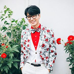 Young Man in Floral Blazer Among Red Flowers