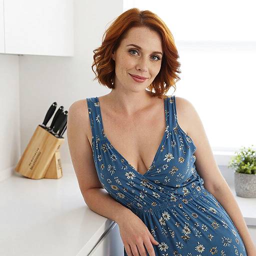Red-Haired Woman in Blue Floral Dress Relaxing in Modern Kitchen