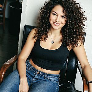 Smiling Woman with Curly Hair in Casual Outfit